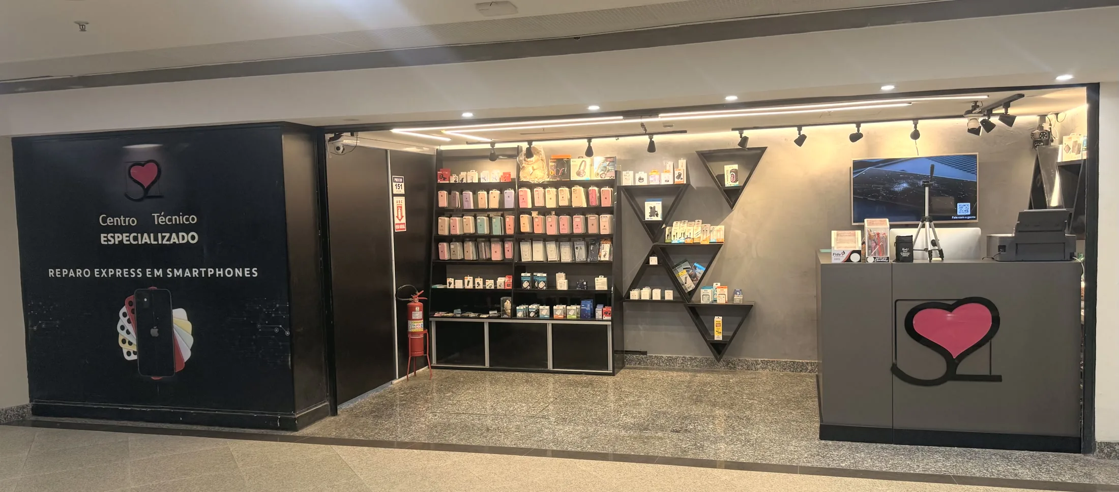 A fachada da S2 Store no Terraço Shopping: painel preto com o coração da marca e os dizeres Centro Técnico Especializado, e ao lado a loja aberta, com a parede de capas e o balcão de atendimento.