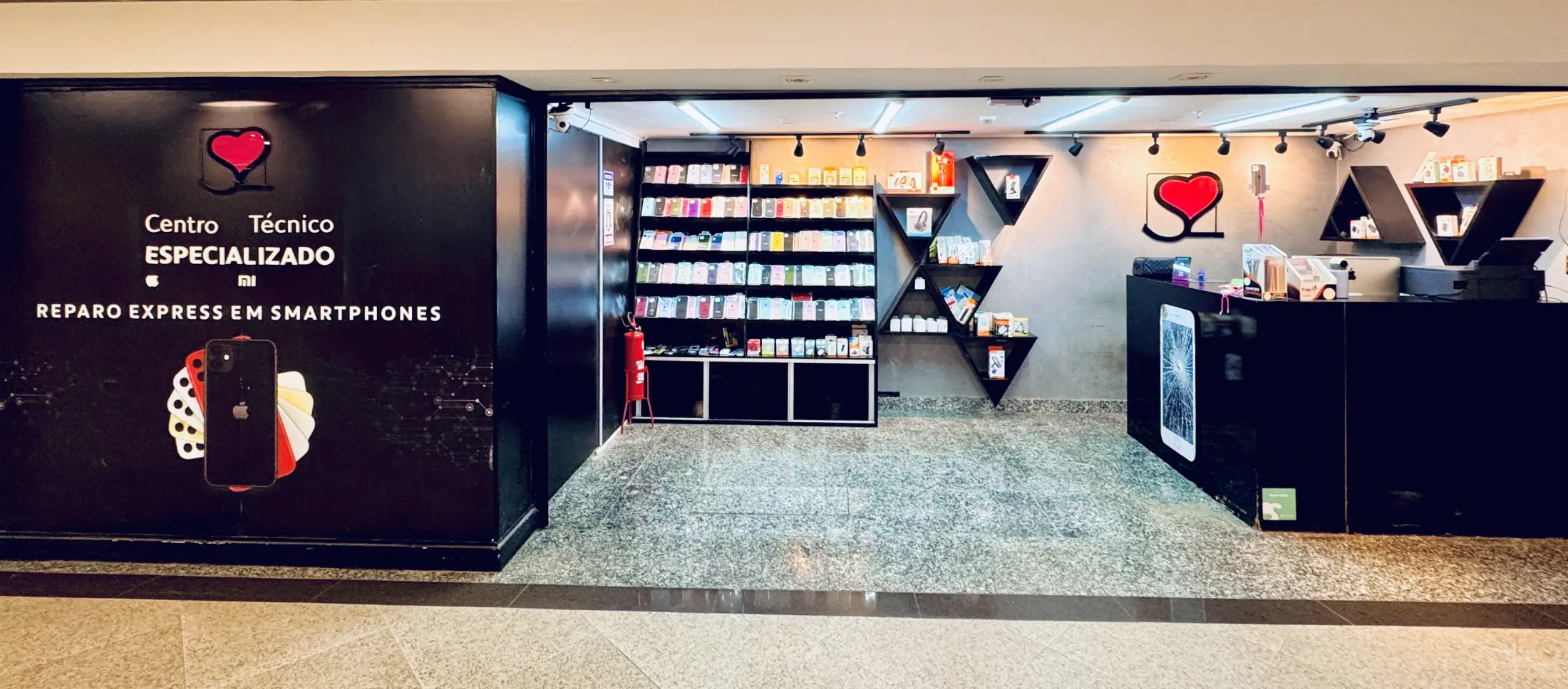 A fachada da S2 Store no Terraço Shopping: painel preto com o coração da marca e os dizeres Centro Técnico Especializado, e ao lado a loja aberta, com a parede de capas e o balcão de atendimento.